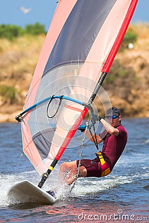 Man in wetsuit on fastmoving windsurfer Stock Photo