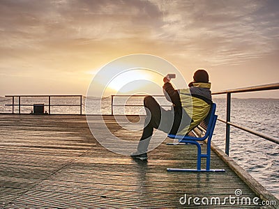 Man on wharf and photograph morning sea Stock Photo