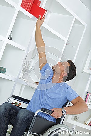 Man on wheelchair during everyday task Stock Photo