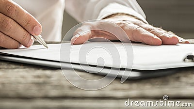 Man in white shirt signing business document Stock Photo