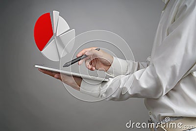 Man in white shirt working with pie chart on a tablet computer, application for budget planning or financial statistics. Stock Photo
