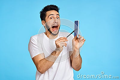 man in white t-shirt notebook with pen student blue background Stock Photo