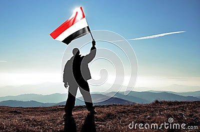 Man winner waving Yemen flag on top of the mountain peak Stock Photo