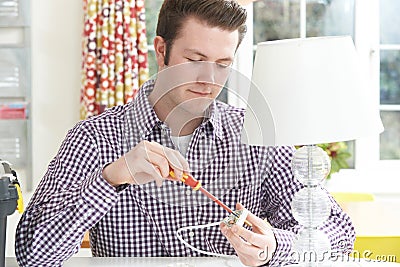 Man Wiring Electrical Plug On Lamp At Home Stock Photo