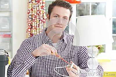 Man Wiring Electrical Plug On Lamp At Home Stock Photo