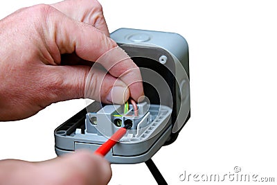 Man wiring an outdoor electric socket using an electrical screwdriver. Isolated on white background Stock Photo