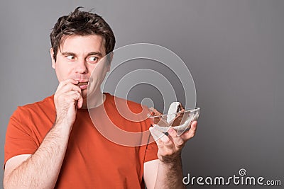 Man wishes to get himself some ice cream. Young man eating ice cream with chocolate. Stock Photo