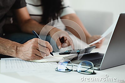 Man and woman are calculating annual tax with calculator and filling form of Individual Income Tax Return. Season to pay Tax and Stock Photo