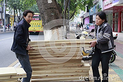 Man and woman carry plank of wood Editorial Stock Photo