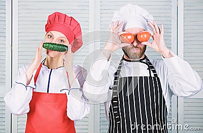 Man and woman chef hold vegetables having fun. Couple play with ingredients for vegan dish. Cooking vegan meal. Cooking Stock Photo