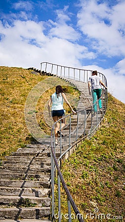 Man and woman are climbing to the mountaintop in the sunny day. Editorial Stock Photo