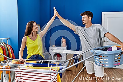 Man and woman couple smiling confident high five at laundry room Stock Photo