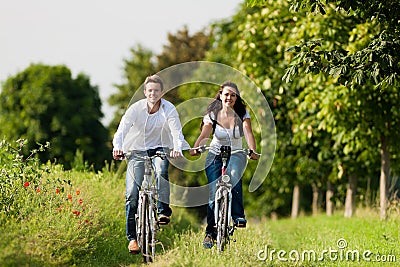 Man and woman cycling in summer Stock Photo