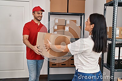 Man and woman deliveryman and worker holding package at storehouse Stock Photo