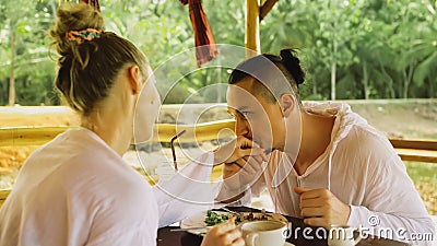 Man and woman eat and drink tasty beverages spending time in traditional local floating cafe on water. Loving happy Stock Photo