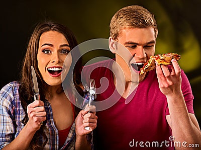 Man and woman eat slice pizza with knife and fork . Stock Photo