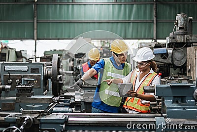 Man and woman engineer industry worker wearing hard hat in factory. Stock Photo