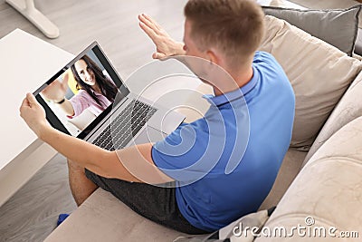 Man and woman greet each other with hand through laptop Stock Photo