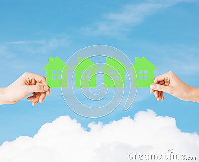 Man and woman hands with many green paper houses Stock Photo