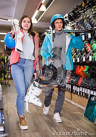 man and woman in helmets choosing sports equipment Stock Photo