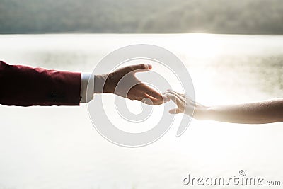 Man and woman holding hands at sunset Stock Photo