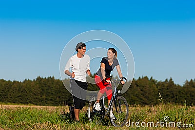 Man and woman jogging and with bicycle Stock Photo