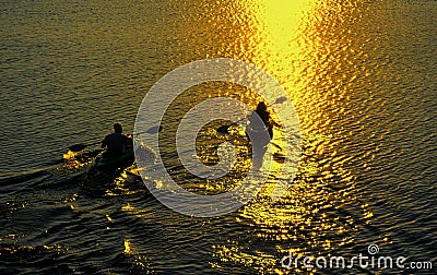 Man and Woman Kayaking at Sunset Stock Photo