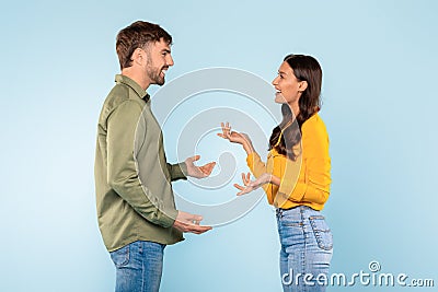 Man and woman in lively discussion on a blue background Stock Photo