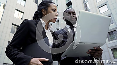 Man and woman looking at laptop outside building, attorneys, brand new evidence Stock Photo