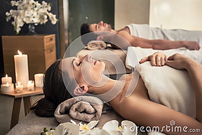 Man and woman lying down on massage beds at Asian wellness center Stock Photo