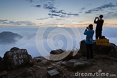 Man and woman photographing at the Lantau Peak at dawn Editorial Stock Photo