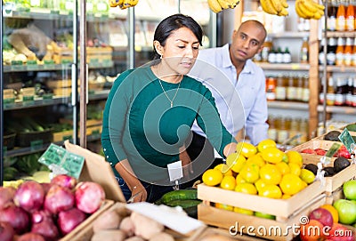 Man and woman picking ripe fruits and vegetables together at supermarket Stock Photo