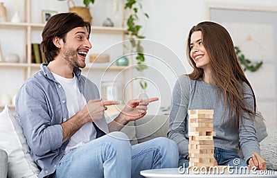 Man and woman playing Jenga at living room at home Stock Photo