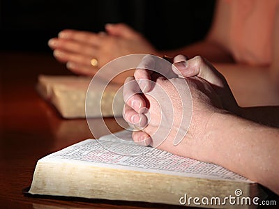 Man and Woman Praying with Holy Bibles Stock Photo