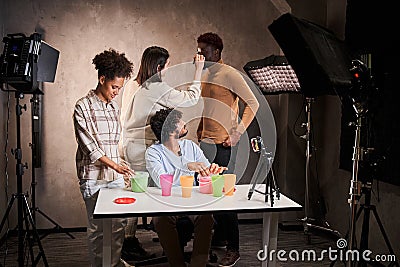 Man and woman preparing to start live stream with kinetic sand while visagiste Stock Photo