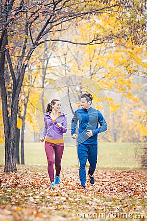 Man and woman running as fitness sport in an autumn park Stock Photo