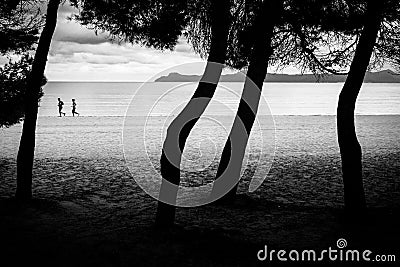 Man and woman running together on the beach. Black and white sport photo Editorial Stock Photo