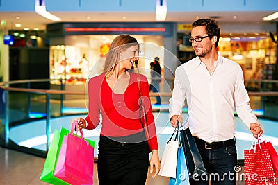 Man and woman in shopping mall with bags Stock Photo