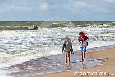 Man and woman are on shore of beach on Baltic Sea in sunny windy Editorial Stock Photo