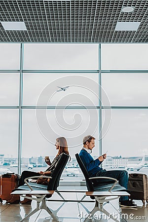 Man and woman are spending time in airport lounge Stock Photo