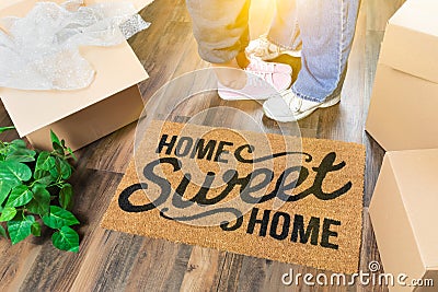 Man and Woman Standing By Home Sweet Home Welcome Mat, Moving Boxes Stock Photo