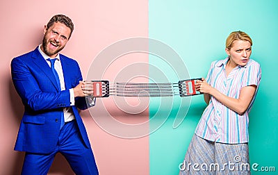 Man and woman stretching expander opposite sides. Business competition between businessman and female. Gender Stock Photo