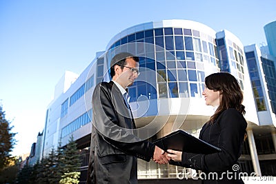 Man and woman in suits shake hands Stock Photo