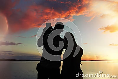 Man and woman at sunset makes a photo Stock Photo