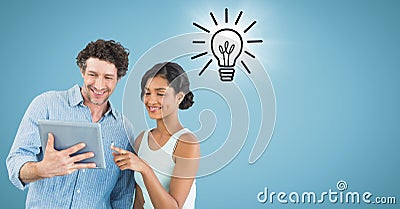 Man and woman with tablet and lightbulb doodle with flare against blue background Stock Photo