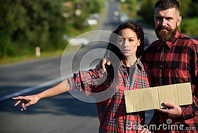 Man and woman try to stop car with cardboard sign Stock Photo