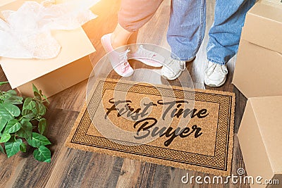 Man and Woman Unpacking Near Our First Time Buyer Welcome Mat, Moving Boxes and Plant Stock Photo