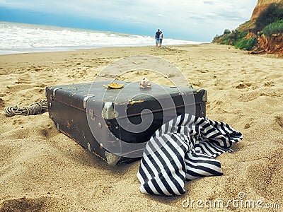 Man and woman in walk on the sand along the sea, frock valise Stock Photo