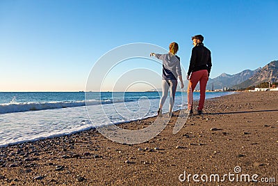Man and Woman walking on Beach and enjoying Sea View Stock Photo
