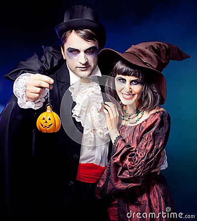 Man and woman wearing as vampire and witch. Carnival. fog. Stock Photo